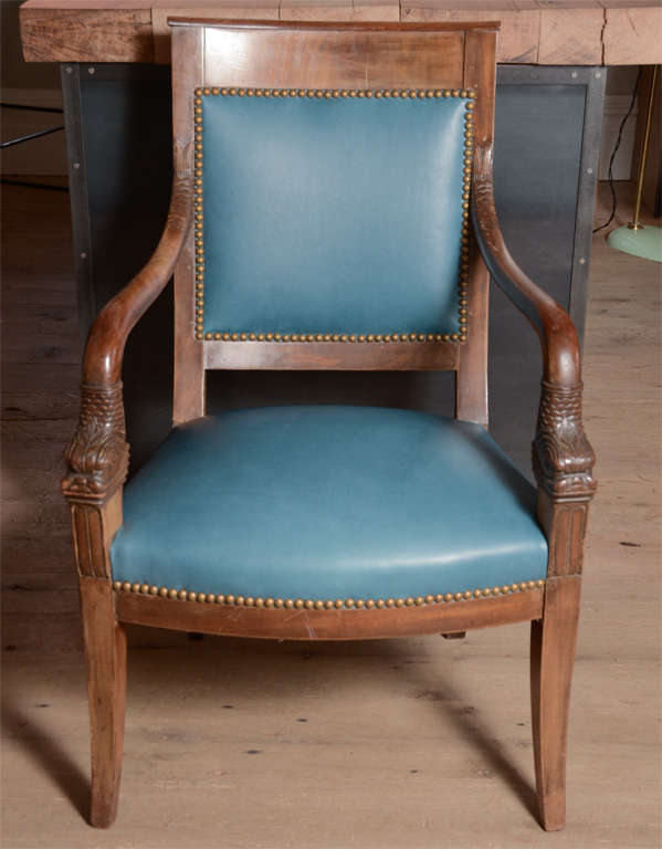 Very elegant and detailed pair of Directoire chairs with carved arm consoles newly re-upholstered in slate blue leather with brass nail heads.