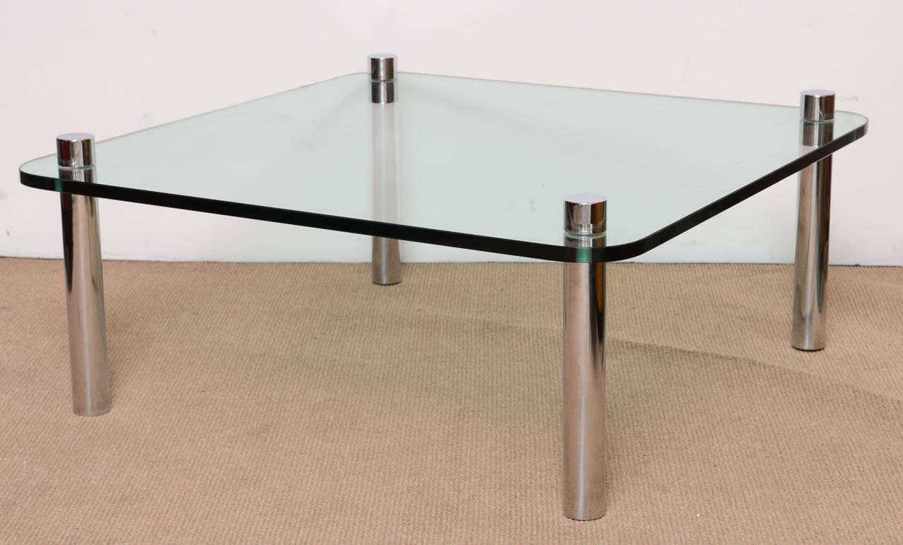 Stunning high quality minimalist chrome and thick glass cocktail table is in perfect condition. The glass has been replaced. The heavy tubular legs pierce the glass. The table is also very sturdy. A perfect addition to any design from Modernist to