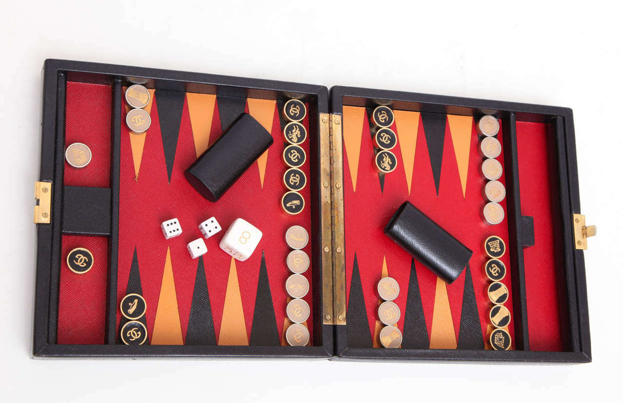 A leather cased backgammon set by Gucci. Felt lined interior.