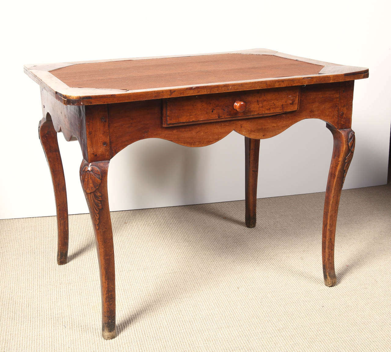 Louis XV period table in cherry, C. 1760 Provincial.  Center drawer, felt top, carving at knees of legs.