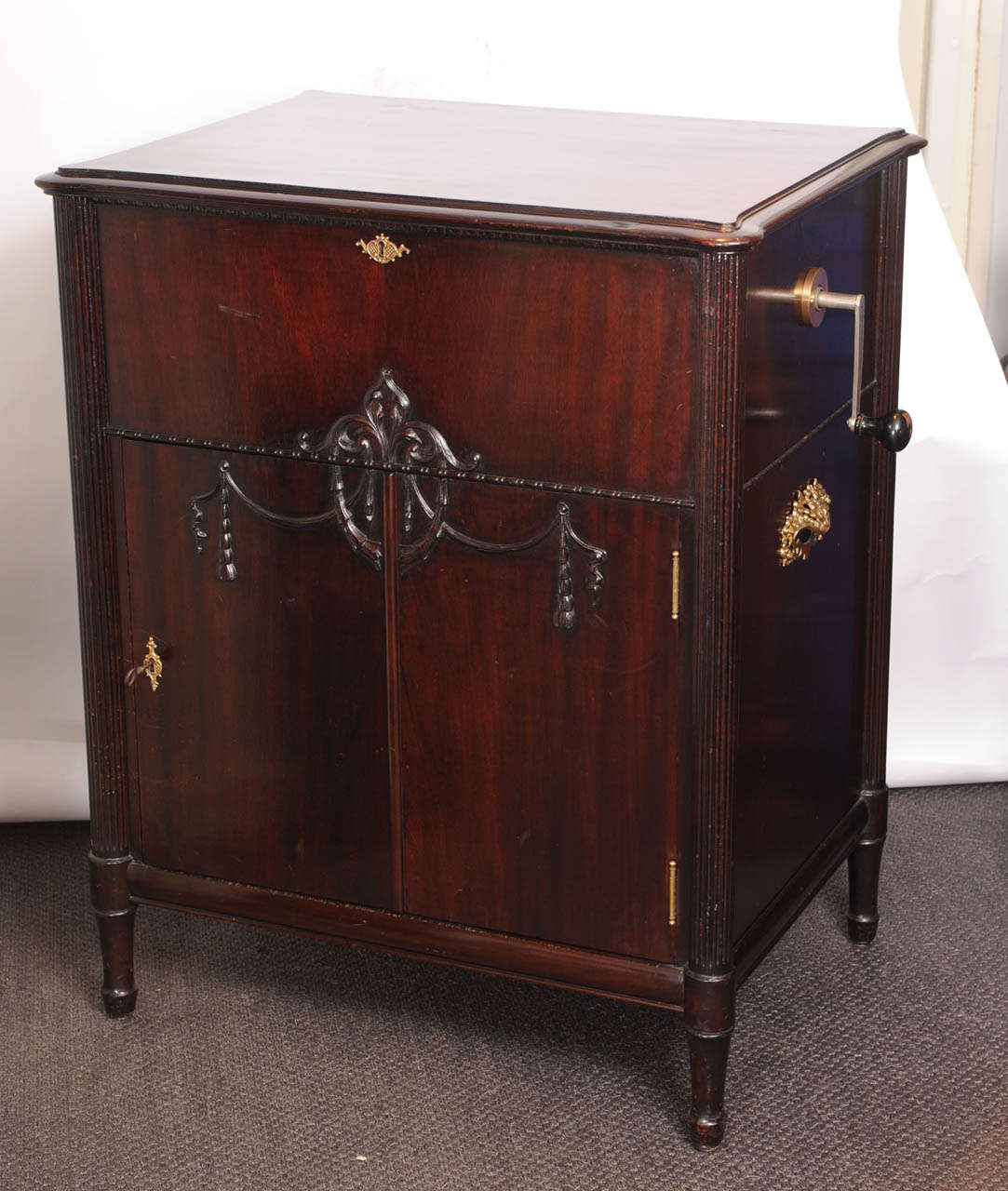 In a Louis XVI-style mahogany veneered cupboard with various discs in the compartment underneath.