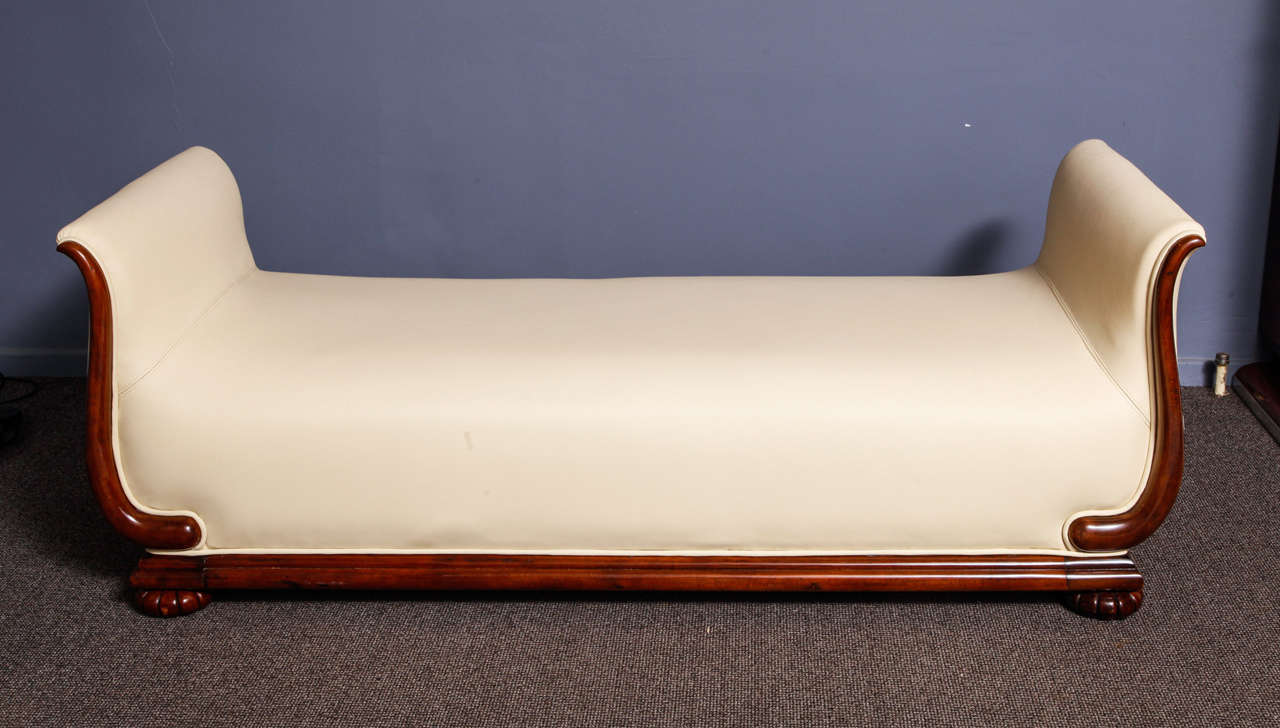 An exceptional Art Deco daybed in walnut, reupholstered with ivory colored leather. The wooden parts were entirely re-polished using handmade lustrous French polish. There are two additional cousins, reupholstered with the same leather. This daybed