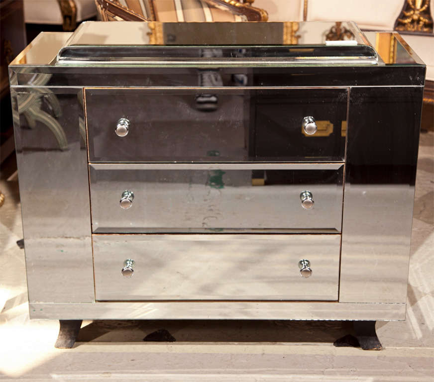 Vintage French Art Deco style chest of drawers, circa 1950s, overall the mirror veneer case fitted with three drawers, raised on wooden block feet.