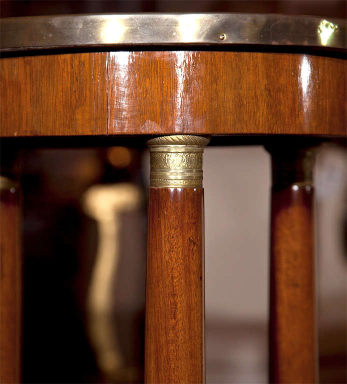  French Empire style mahogany pedestal, late 19th century, the grey veined circular marble with bronze banding, supported by three circular columns, raised on a triangular block base and bun feet.