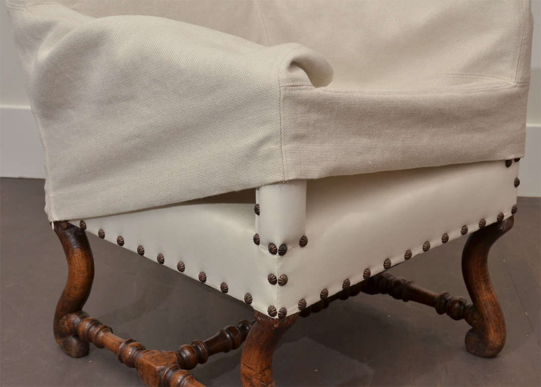 Antique Arm Chair with wooden Legs + Linen Slipcover. Upholstered in Muslin under slipcover with nail heads. <br />
arm height: 24