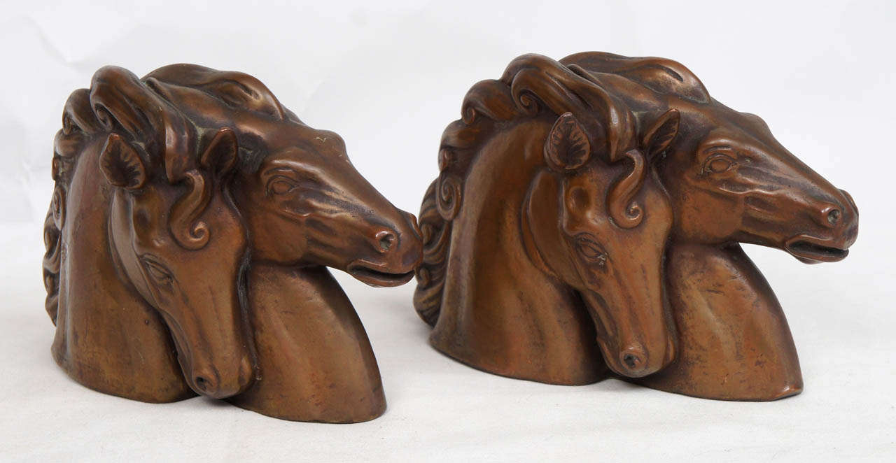Stylish and impressive pair of horsehead bookends. They seem to have a bronzed patina but may be made of mixed metal. They are heavy and functional and make a great statement for the horse lover!