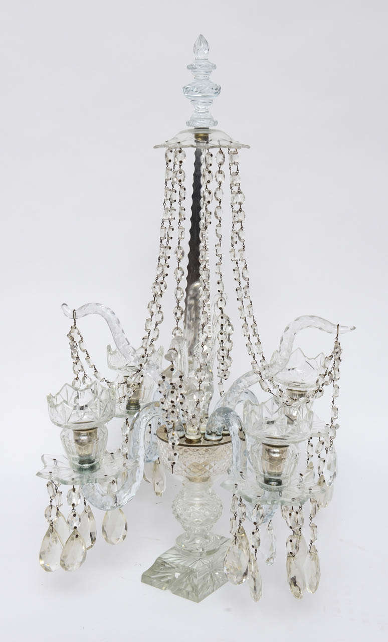 Pair of English Crystal Candelabras each with four candle arms with hand cut candle cups & bobeches with hanging prisms.  In the center is a etched tapered spear holding a canopy that has crystals draping to the candle arms. 

A candelabrum
