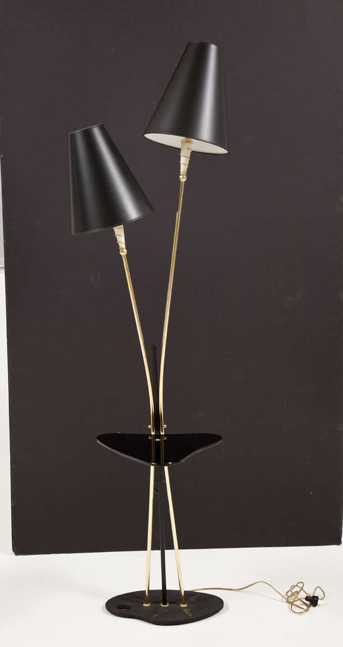 Decorative, midcentury, two head French brass floor lamp, with a black glass detail, circa 1950.
