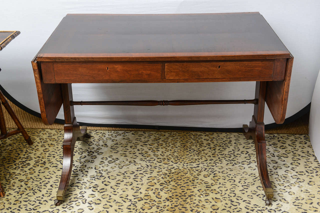 This is a very nice rosewood parter sofa table made in England, circa 1870.

This has been re finished at some time and looks fine.

To the edges it has thick cross band satinwood veneer and rose wood to the center.

Either side there is a
