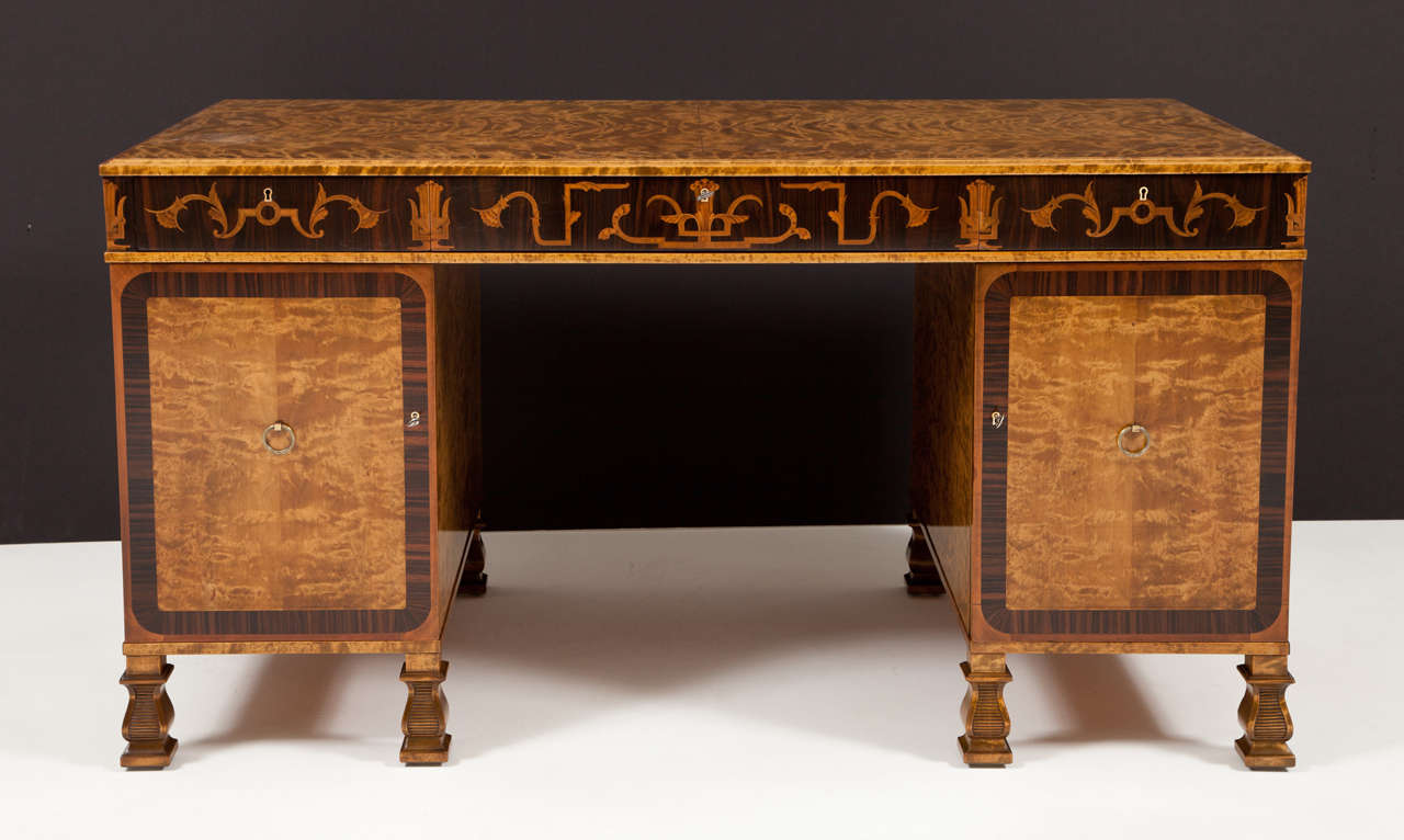 A Swedish Grace period flamed birch and rosewood pedestal desk with fruitwood inlays, designed by the renowned architect and furniture designer: Carl Malmsten (1888-1972) Produced by A.B Svenska Mobelfabrikerna - Bodafors, Circa 1930-1940. In three