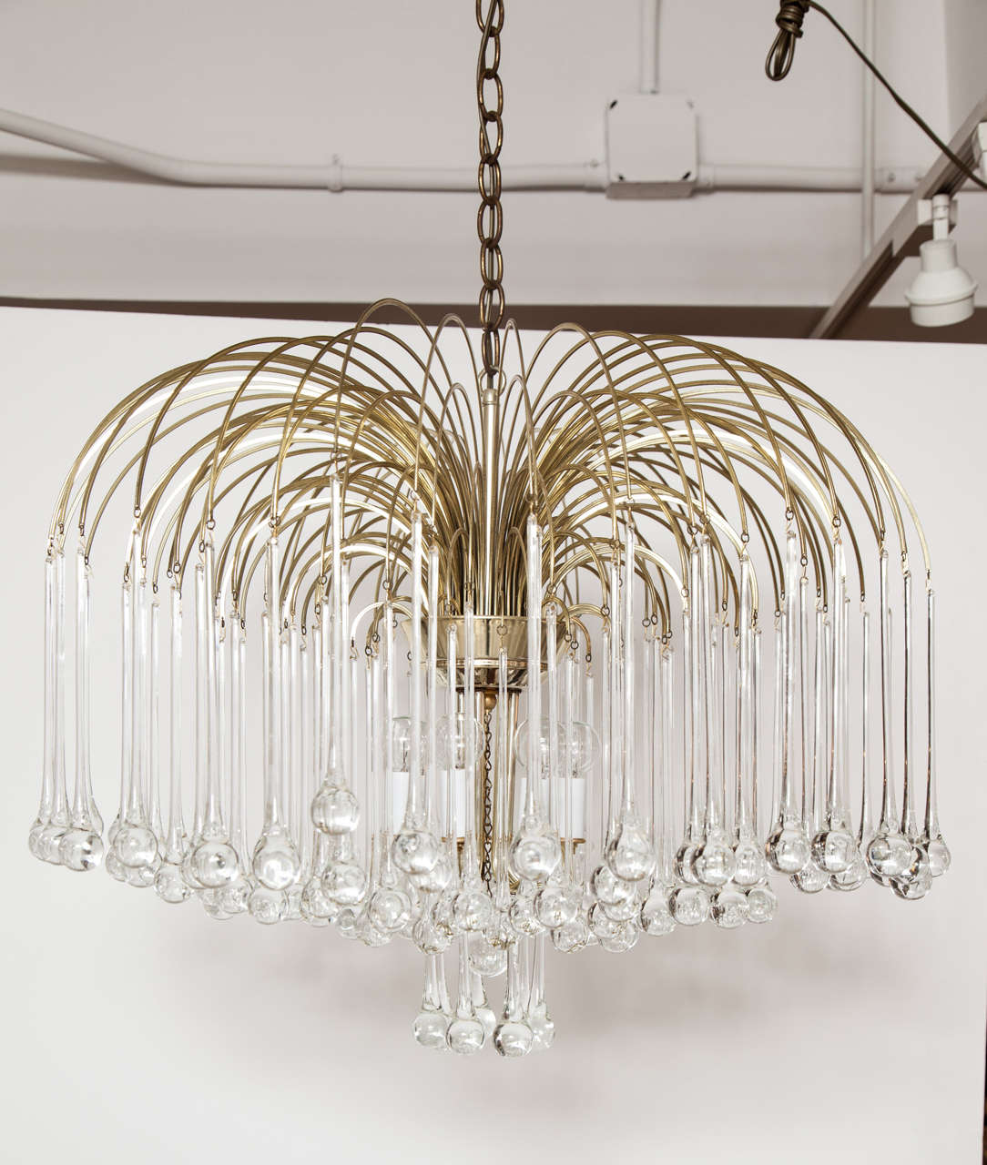 A stunning Italian brass chandelier with crystal tear drop shaped drops. Italy, circa 1970. New wiring. Takes three candelabra base bulbs, 60 watts max.