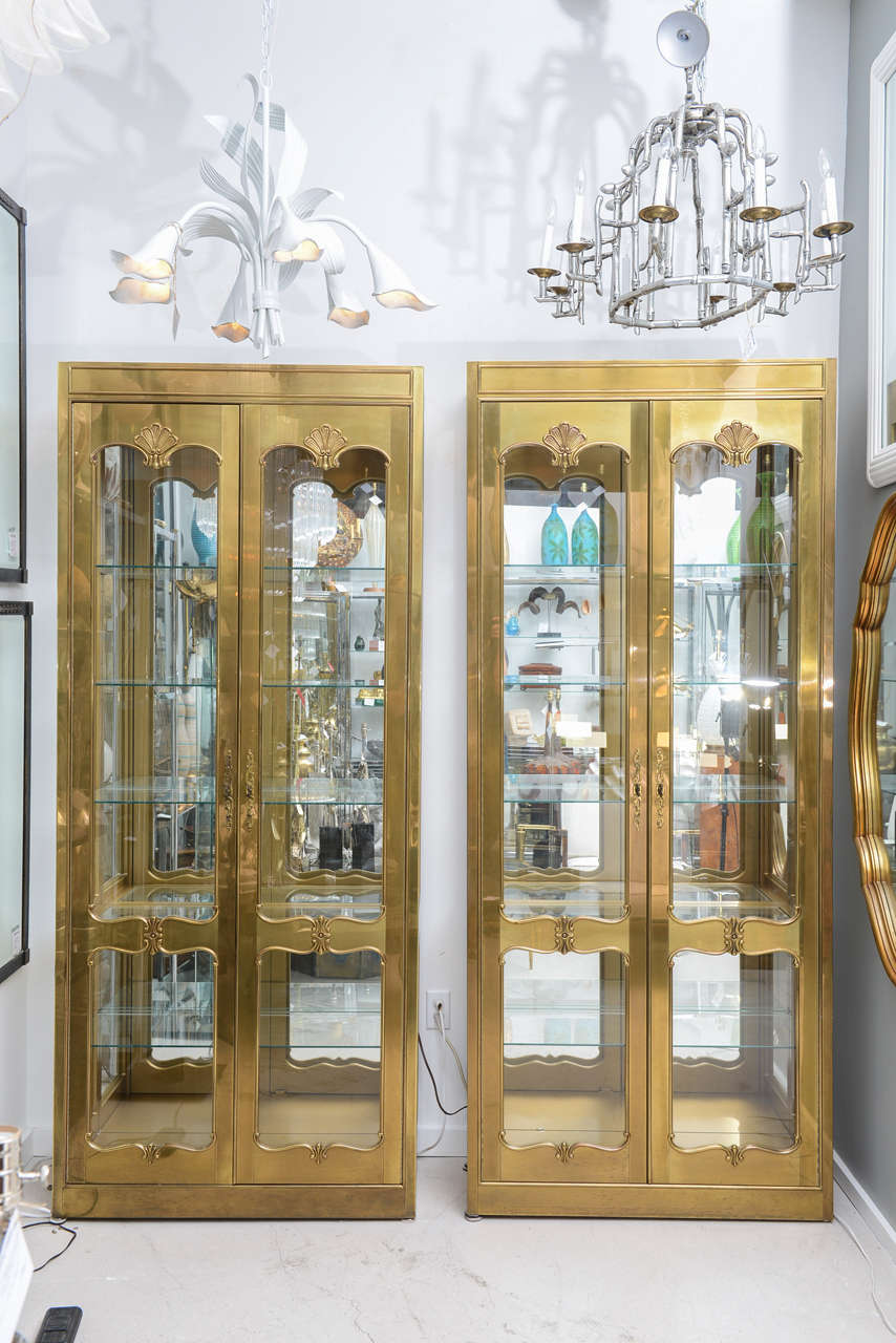 Pair of tall Mastercraft vitrines featuring six shelves for display. The cabinets illuminate.