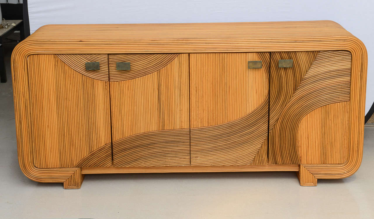 Long four-door credenza with rounded edges. Exterior is fashioned out of reed in a swirling pattern, similar to that of Gabriella Crespi's work.