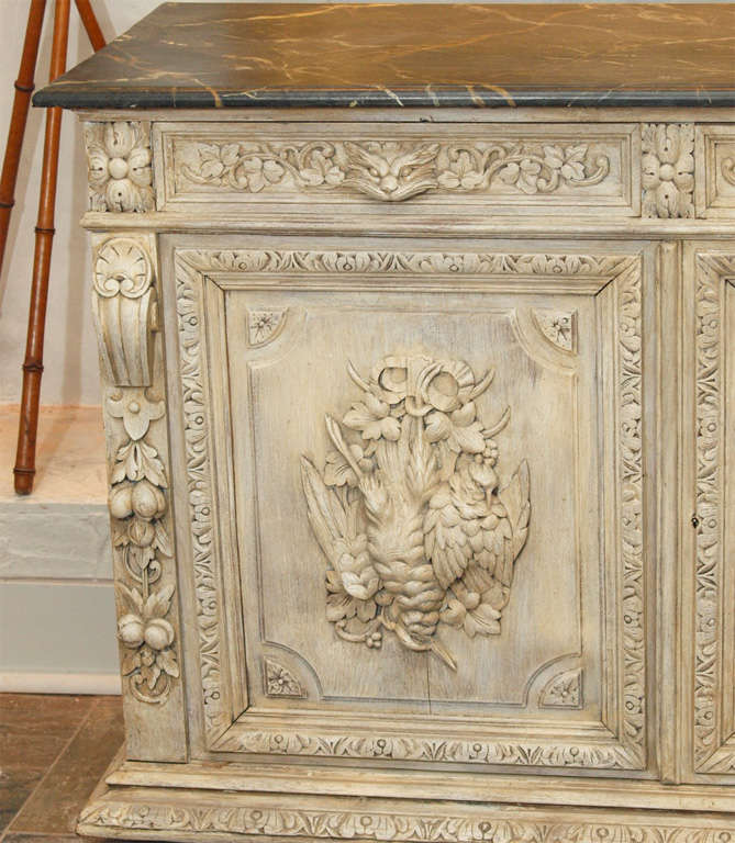 Huntboard with nicely carved game and fish motif. Faux marble painted top and cream painted finish.  Two drawers and two doors with interior shelves. American circa 1875