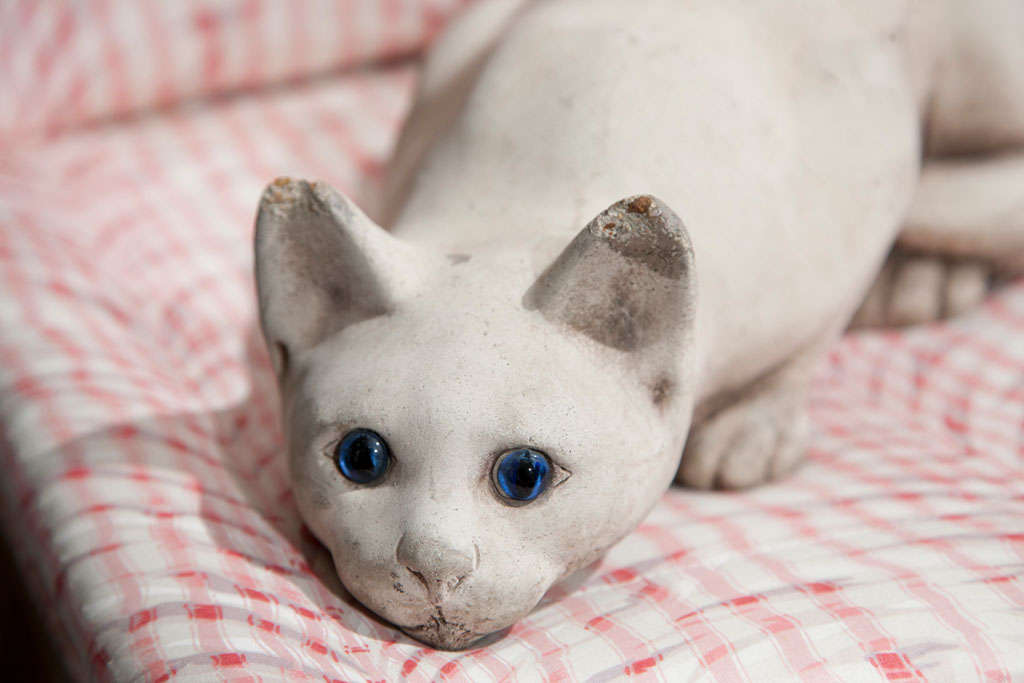 This crouching cast stone cat has a lovely matte terracotta finish and blue glass eyes.  It would make a whimsical addition to a garden peeking out from underneath a shrub or guarding a door.