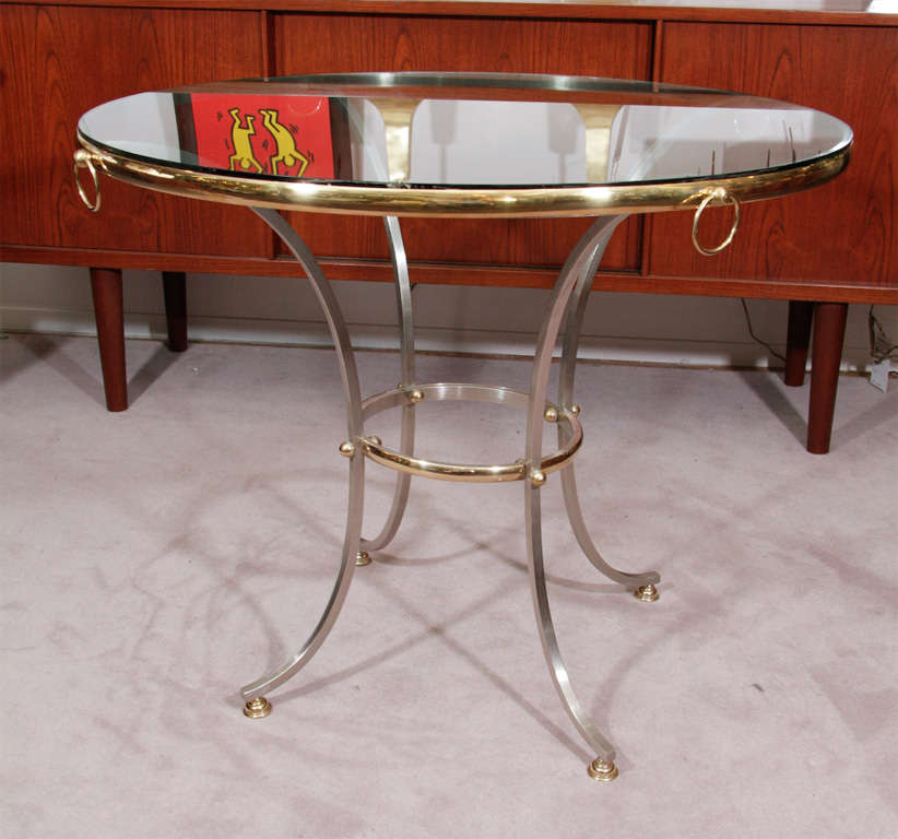 Circular glass top occasional or bistro table by Maison Jansen with brass accented steel frame.<br />
<br />
Reduced From: $2,450