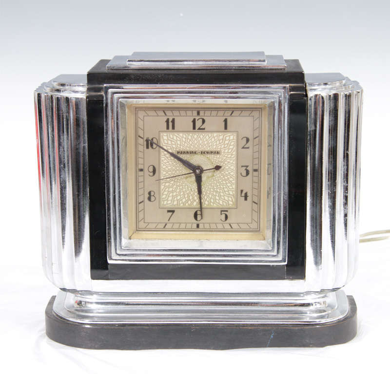Rare Art Deco table top clock by Manning-Bowman in chrome with black bakelite detailing and black lacquered wood base. The company was originally founded in 1832 in Middletown Conn. and in 1872 purchased by, and named for, Edward Manning and Robert