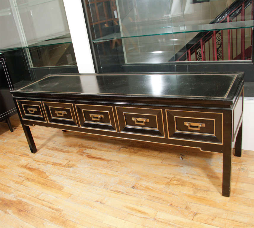 Sleek and low console/bench with five drawers. Lacquered wood with gilt wood finish.