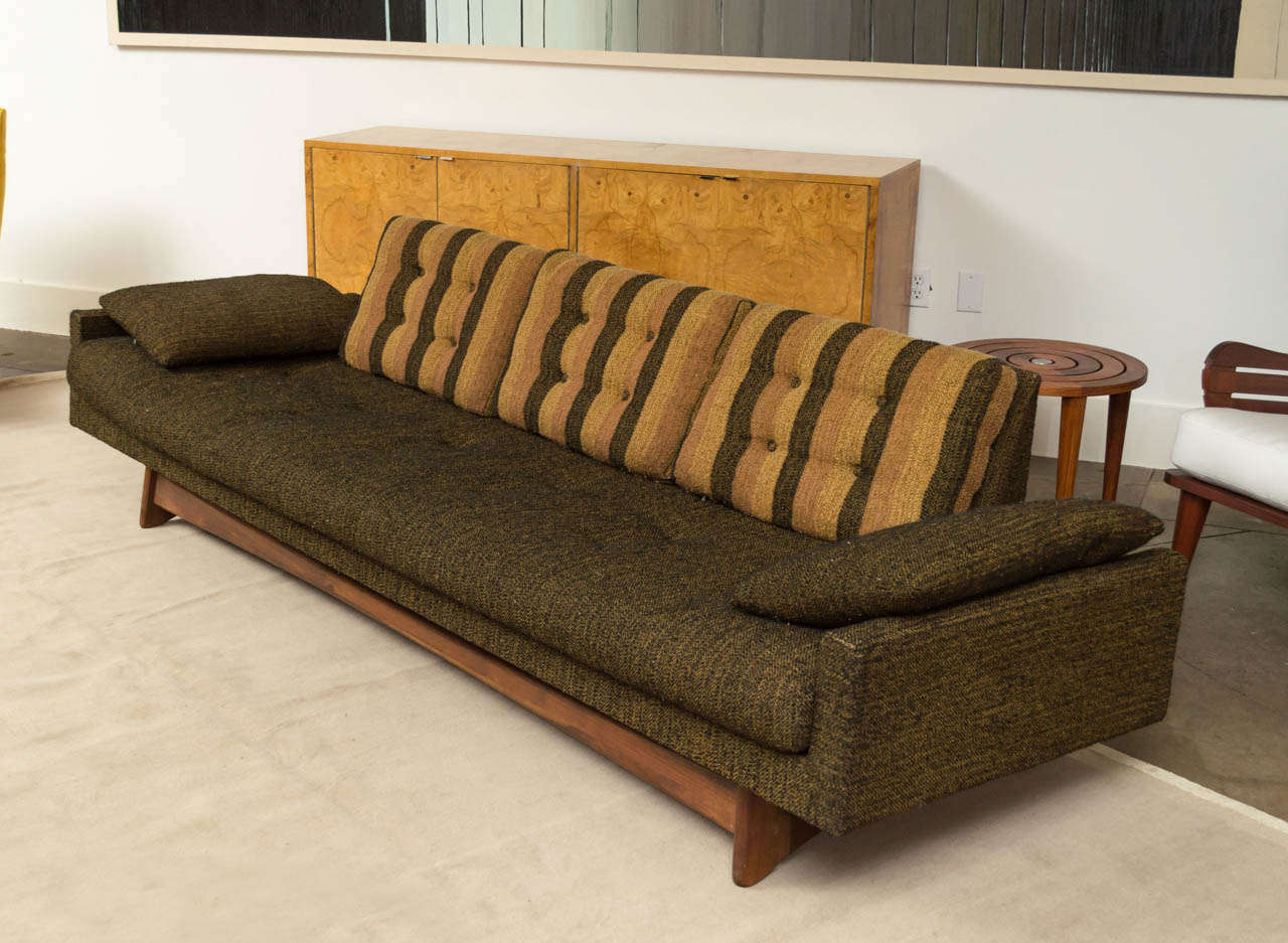 A sofa by Adrian Pearsall for Craft associates. Sculptured solid
walnut base with loose back and arm cushions - Gondola deck over
rubber straps and incredibly comfortable