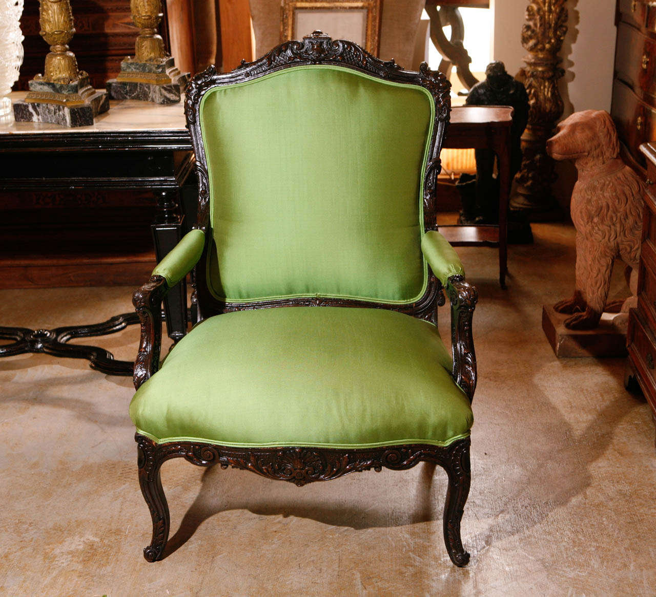 Pair of richly hand-carved armchairs with faces and foliate details. Covered in apple-green, Coraggio fabric.