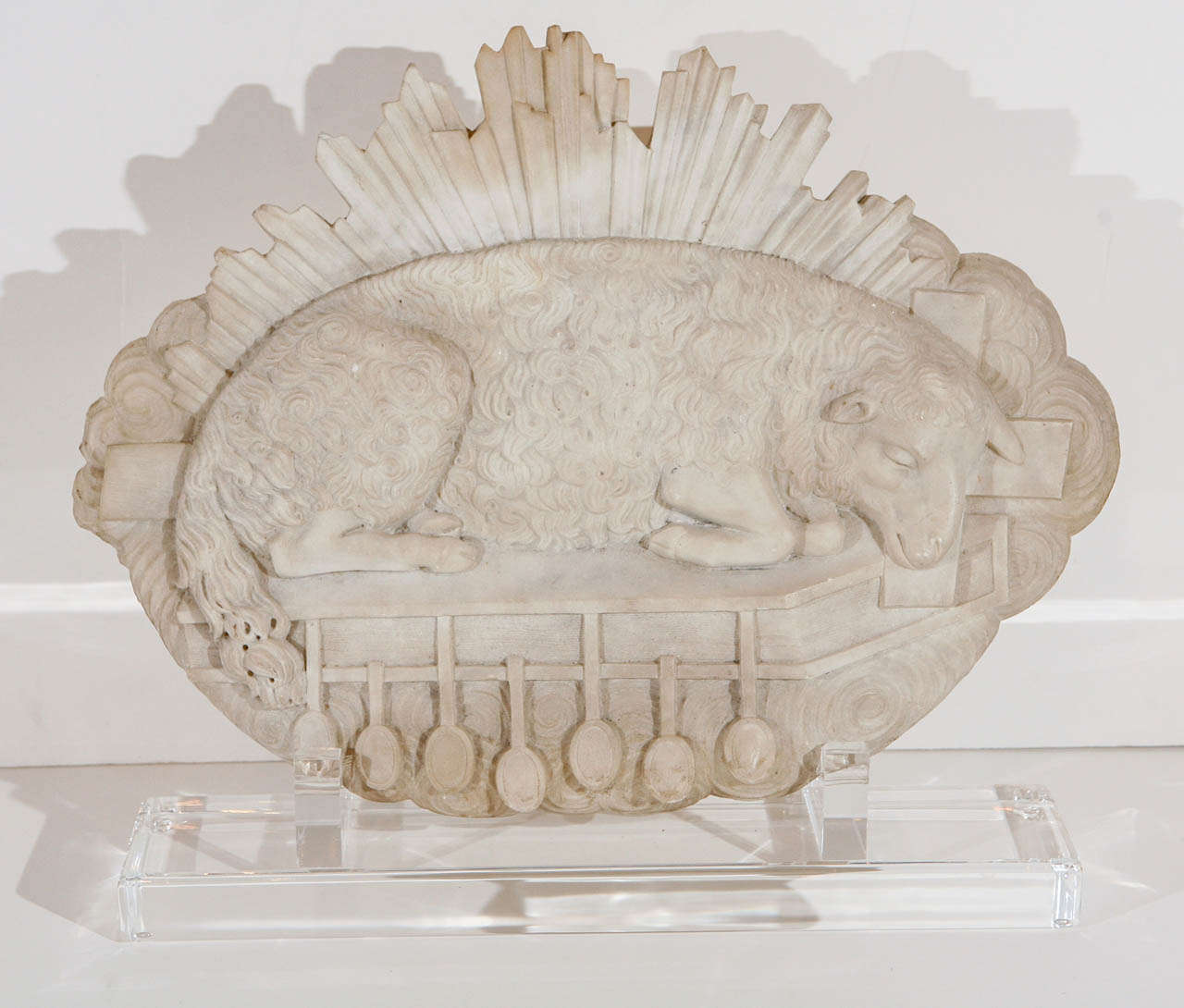 Hand-carved, Cararra marble relief of the lamb of God above the seven seals of the Apocalypse mounted on a custom, Lucite base.