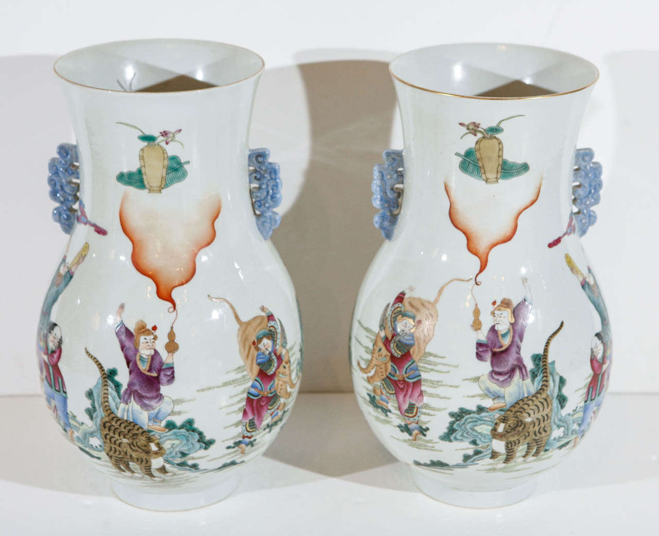 Pair of richly colored, hand-painted, parcel gilt, Chinese vases with exotic animals and costumed figures.