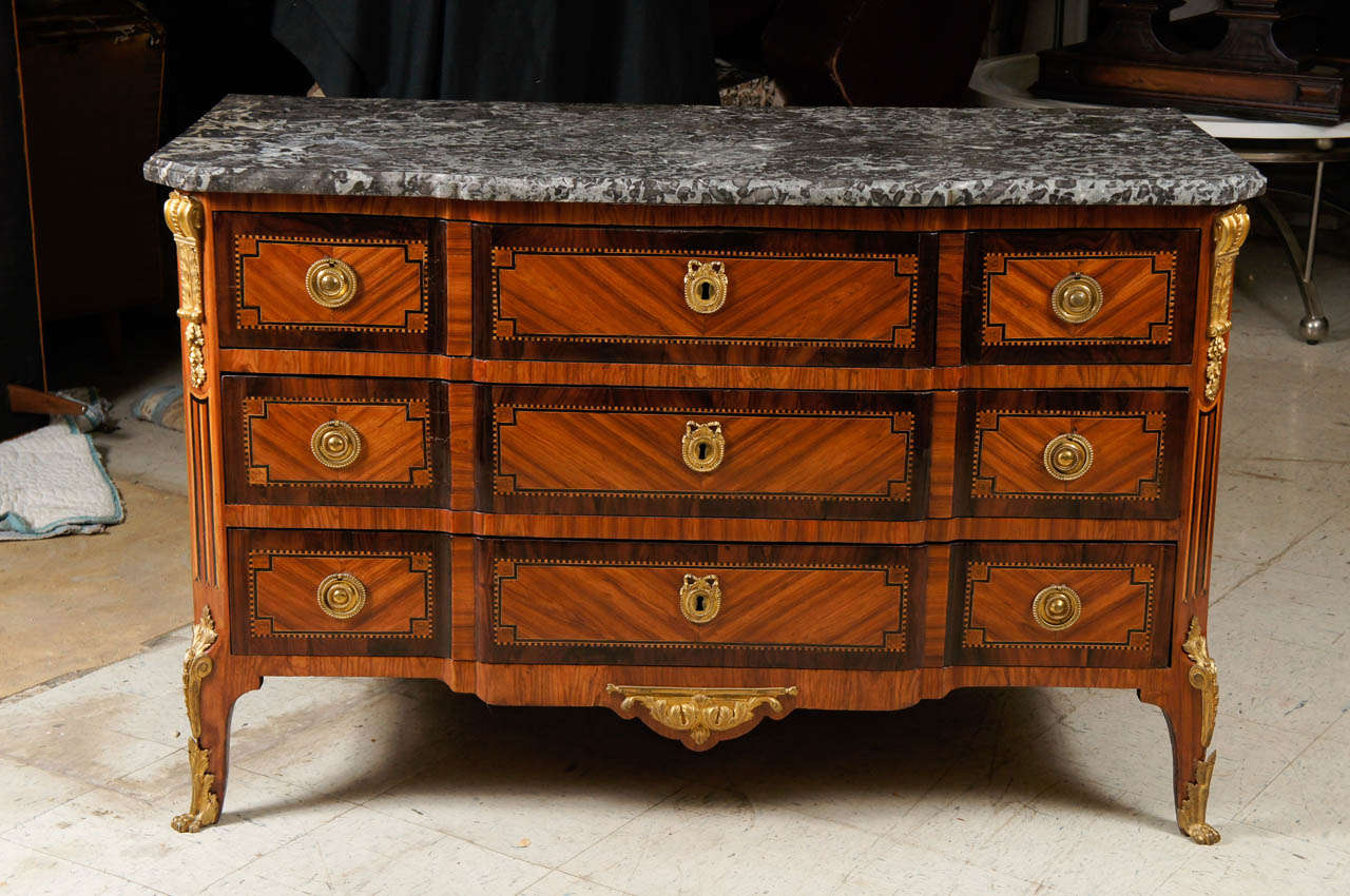 This very fine formal transitional commode is of the period circa 1770 is crafted from oak secondary woods with tulipwood, kingwood and satinwood veneers. The break front form is enlivened with good quality ormolu mounts which are original and the