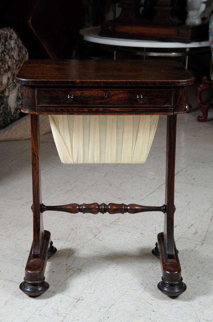 This simple classical piece of furniture was used as a ladies sewing table and to house, in the lower section, works in process. This table has the added advantage of having a compartmented top drawer designed as a small desk. The graining done on a