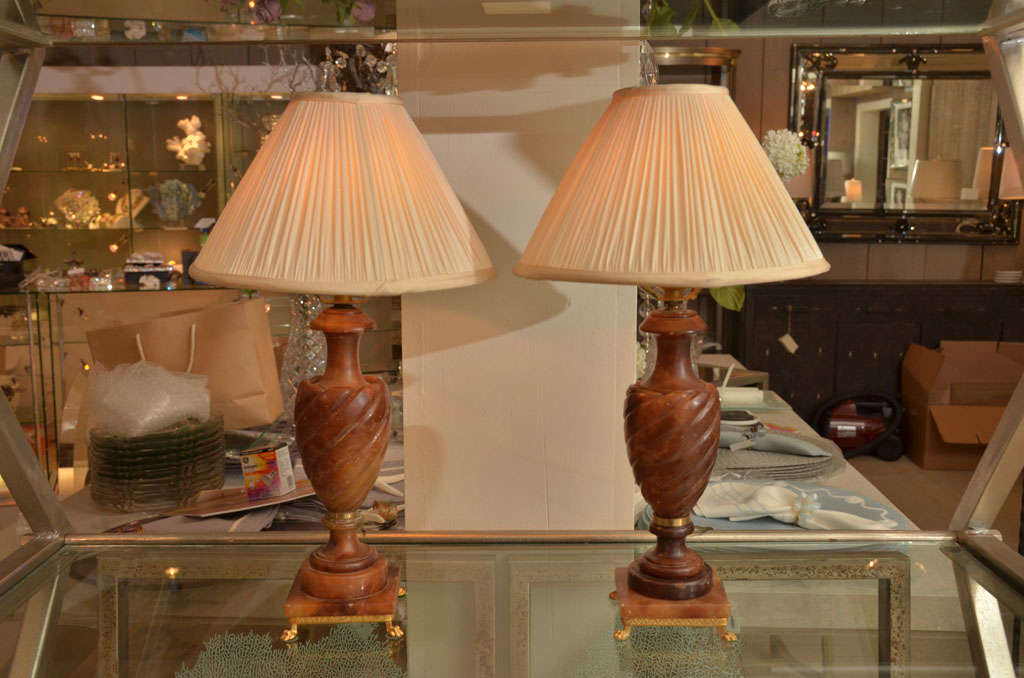 Beautiful and rare pair of dark amber swirled alabaster lamps on marble footed bases