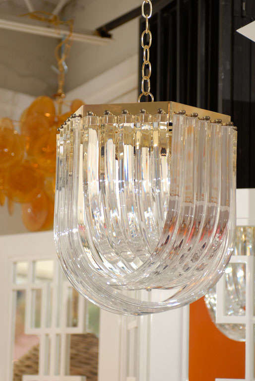 * vintage<br />
* elegant hexagon lucite and brass chandelier<br />
* u-shape lucite pieces hang from 6-sided brass frame<br />
* each lucite piece is secured to frame with brass round ball screws<br />
* 3 layers of u-shape lucite pieces create