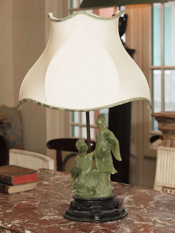 A jade carving mounted on carved rosewood, made into lamp with custom shade