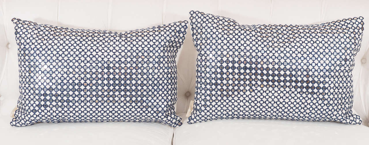 A pair of pillows with sequins surrounded by a dark navy stitching, backed in a cream chenille and very chic!