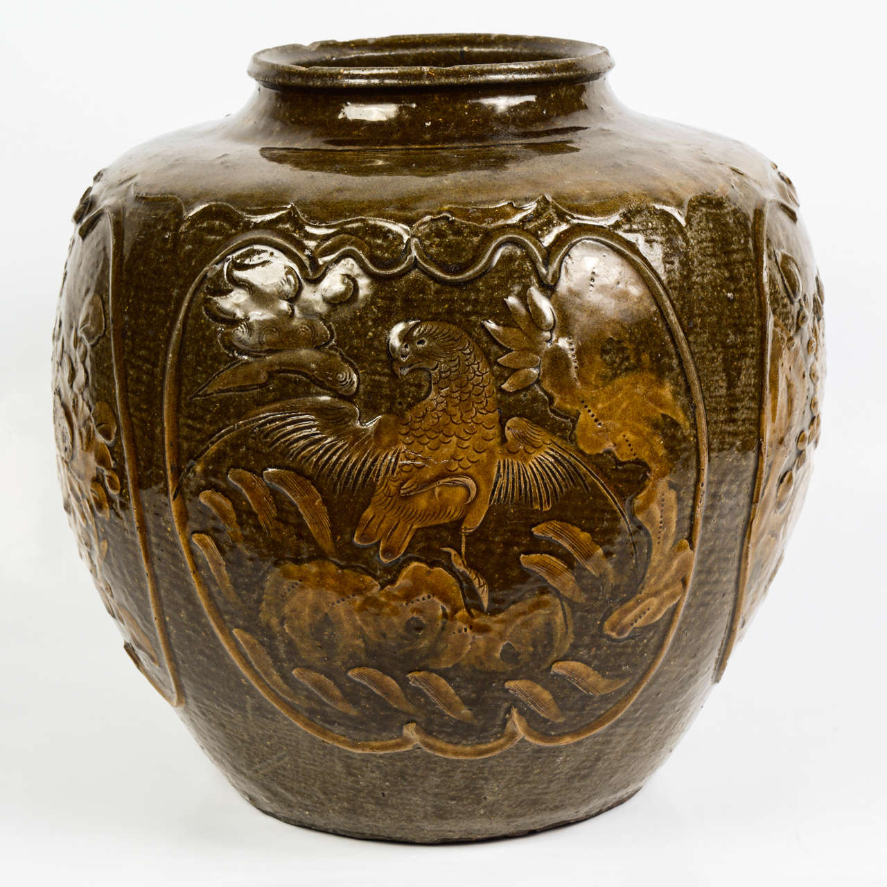Large brown glazed stoneware urn with chrysanthemums decor on one side and a prancing horse on the other side.
This type of urn is named after Martaban, harbour on the west coast of modern Burma, which was an important trade link between China and