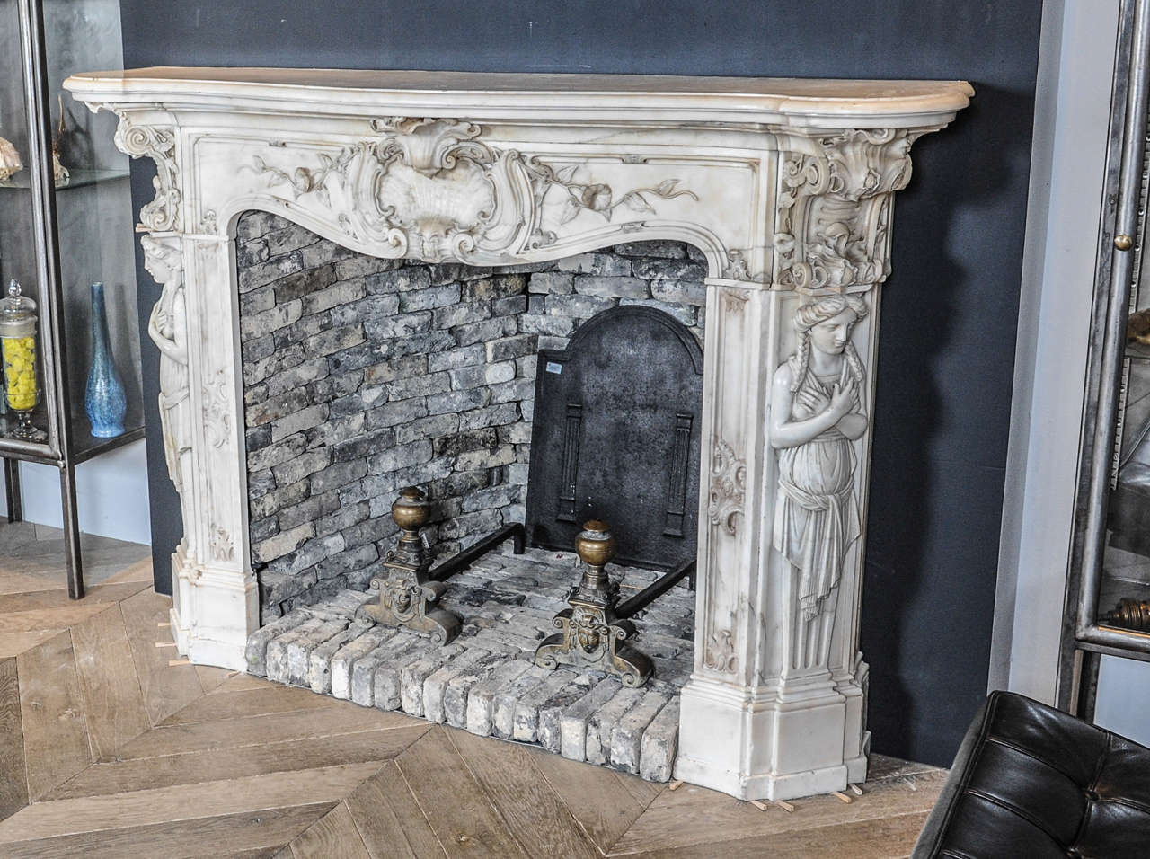 A richly carved 19th century French white Statuario (Carrara) marble fireplace or mantel piece in Rococo style, the breakfront shelf above a frieze with detailed double serpentine Rococo shelves, flanked by typical C-scrolls and flower tendrils on