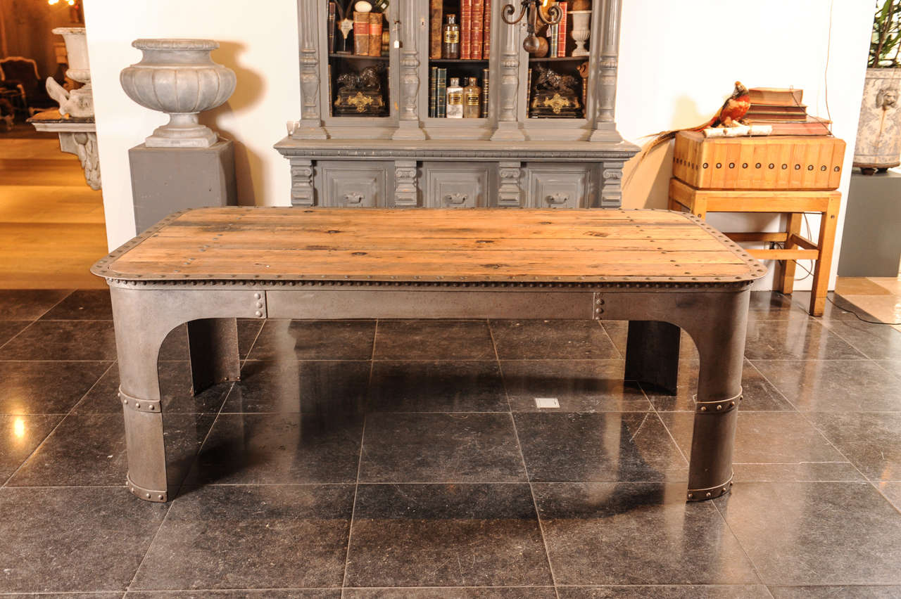A large French Industrial weathered riveted steel and oak table. The steel derived from an old water tank; the oak top from an old waggon.