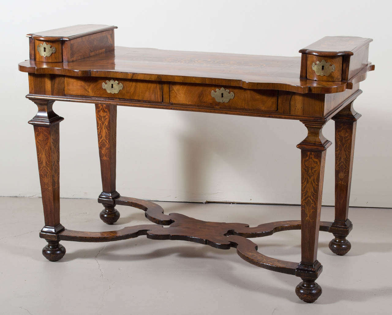 Very rare and unusual walnut and satinwood inlaid Italian desk. There are two drawers below the writing surface and two raised drawers above. The desk is supported by four inlaid and tapered legs that rest on a scroll shaped cross stretcher raised