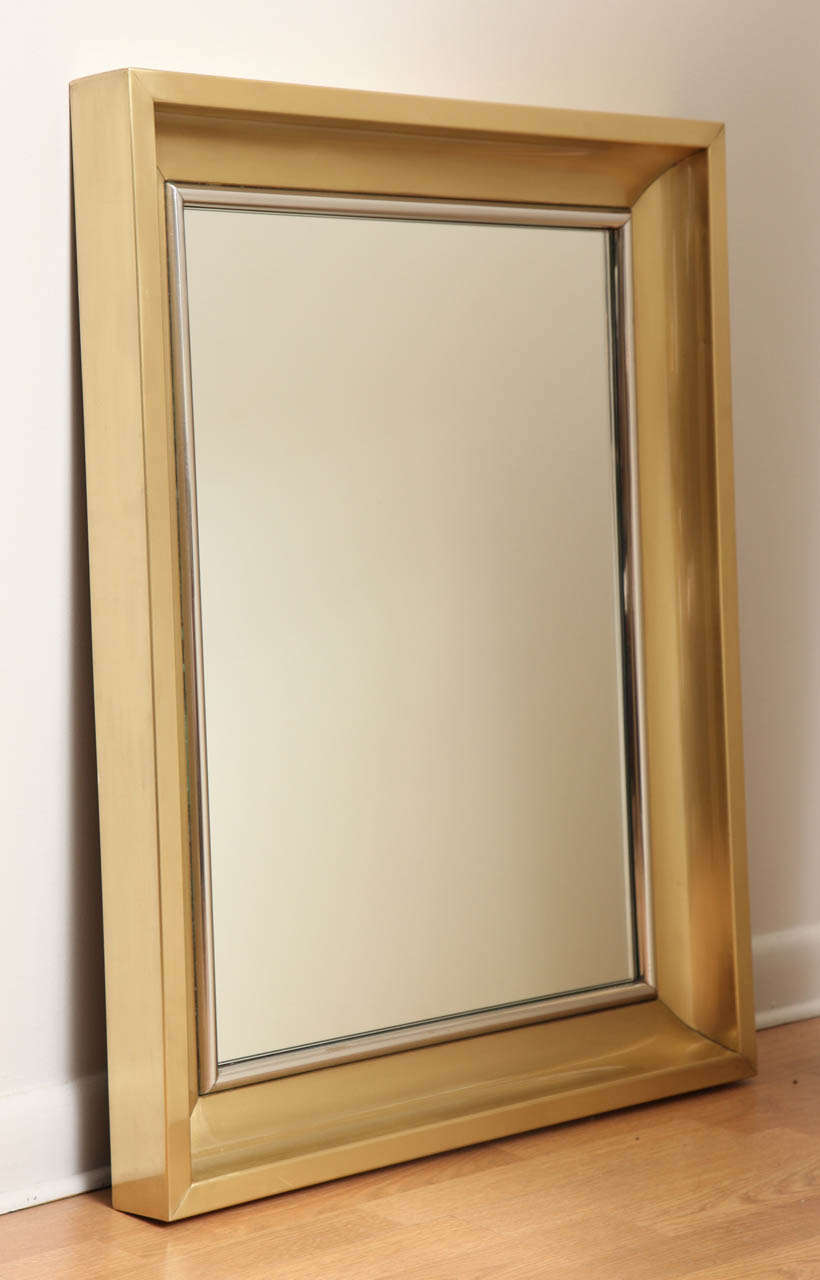 Brass framed wall mirror with polished nickel edge detail around mirror.