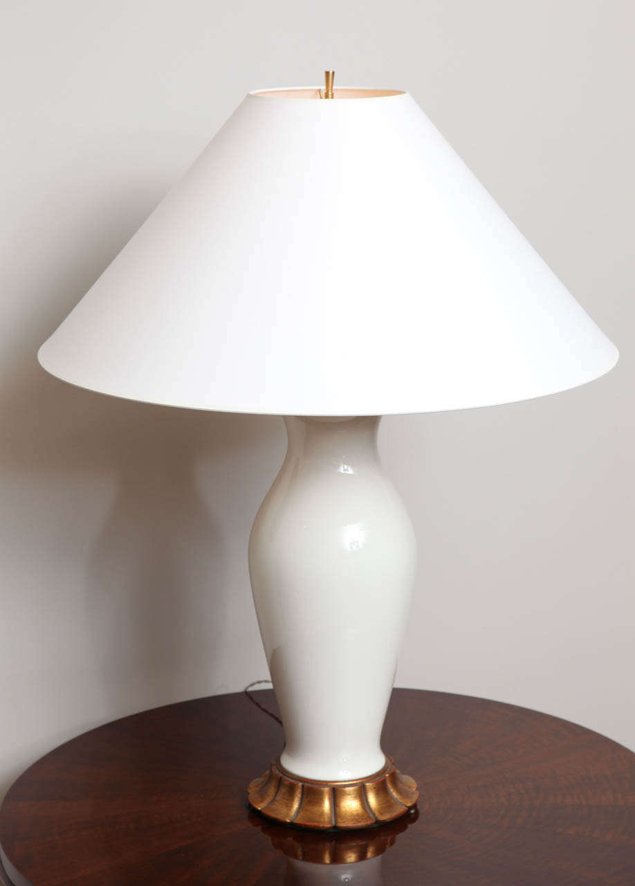 A pair of Modernist white ceramic "Blanc de Chine" table lamps with white shades. Bois dore scalloped base.