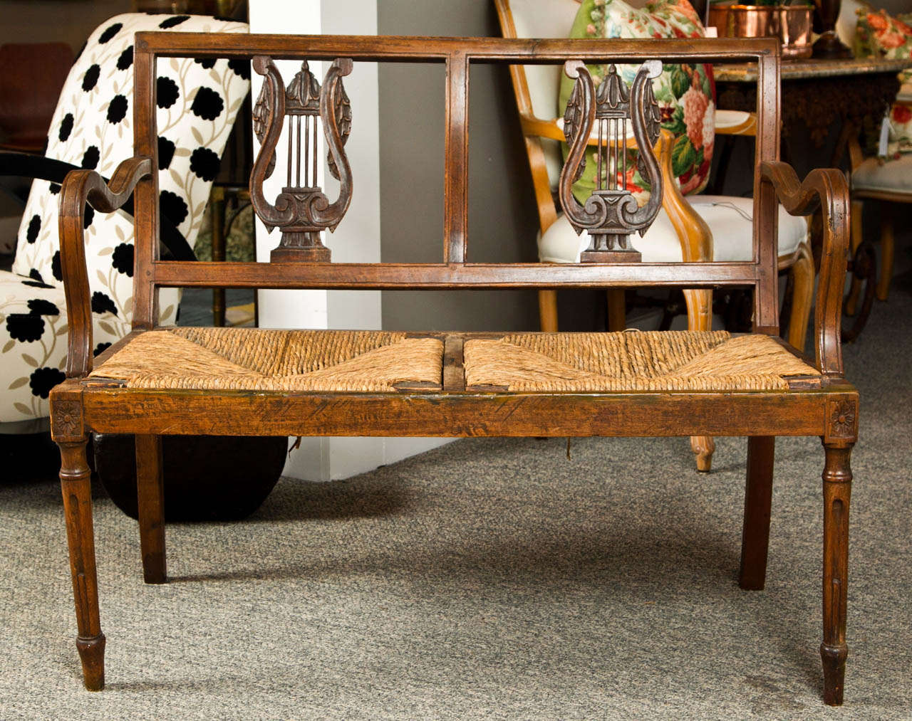 Carved walnut bench, late 19th century, Italy. Beautiful aged walnut with original rush seats. Finely carved neoclassical details. Minor restoration.