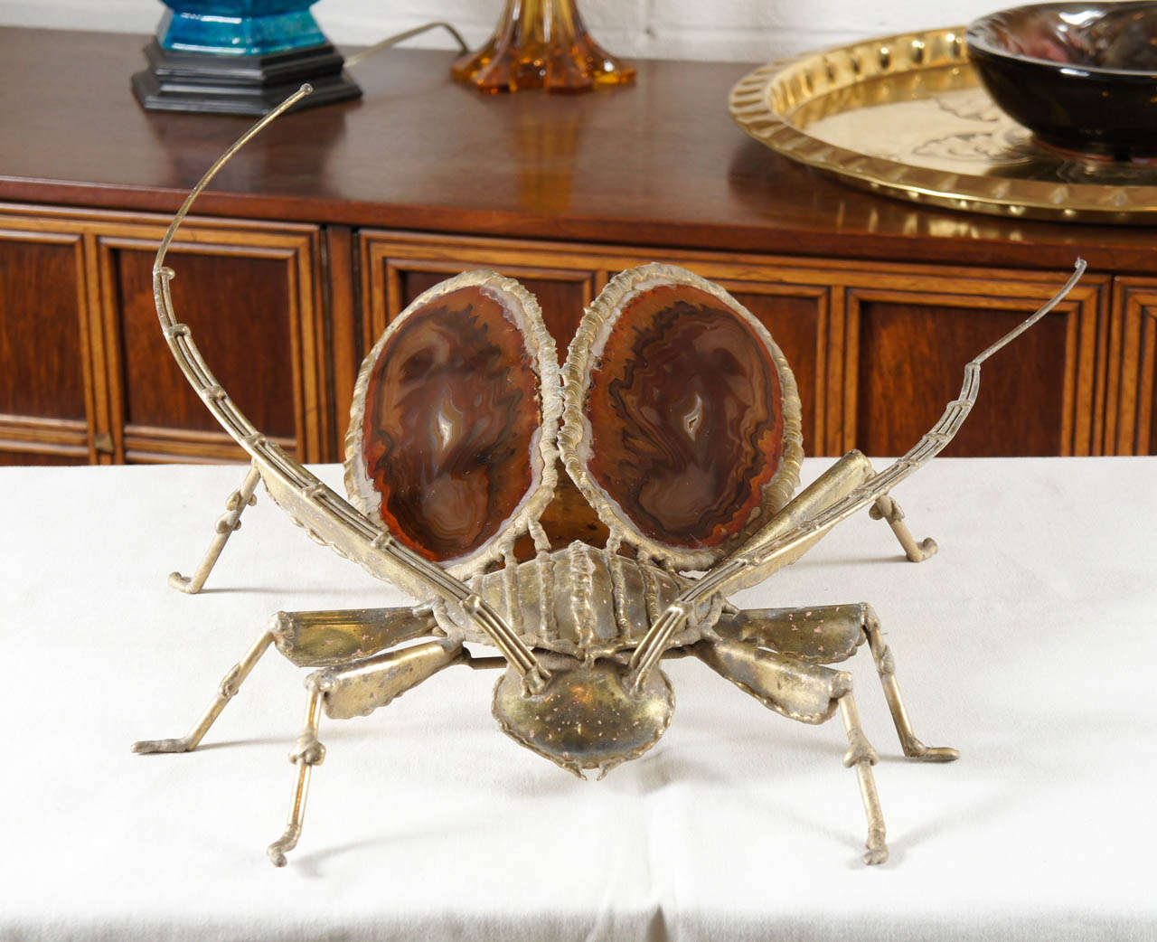 Here is an amazing beetle sconce by Jacques Duval-Brasseur.
The body is bronze and the wings are made of Agate.
This fixture works as a table lamp or a sconce.