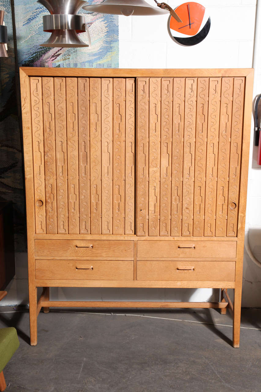 Vintage 1940s Multi-Purpose Oak Cabinet by Hans J. Wegner

This is an early oak cabinet by Hans Wegner for Mikael Laursen.  It was produced between 1942 and 1946.  It features 6 trays, 2 shelves and 4 drawers.  The doors are composed of tongue and