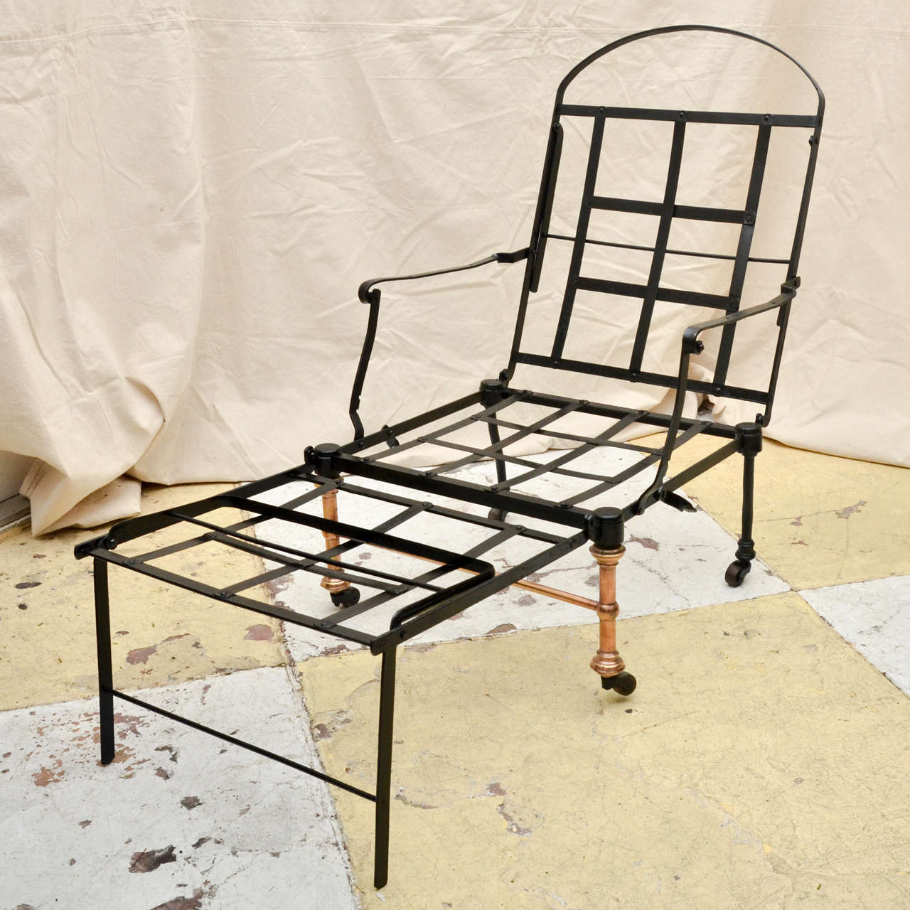 19th century English black painted steel and cast iron Campaign chaise longue with brass front legs. The chaise longue folds to a chair and extends to camp bed. It folds for easy transport. Military officers used it as a multipurpose piece of