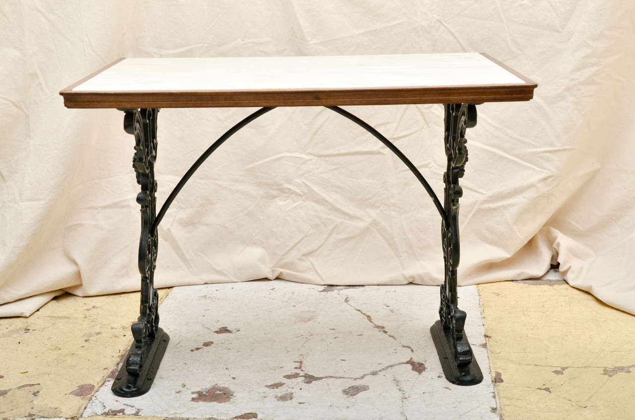 English Victorian Rectangular Marble Top Pub Table.The Base Has Foliate Scrolled Ends With A Mustached Satyr Mask . The Top Has Moulded Wood Surround. It Is Painted A Dark Green. Great As A Console , Breakfast Table Or End Table.