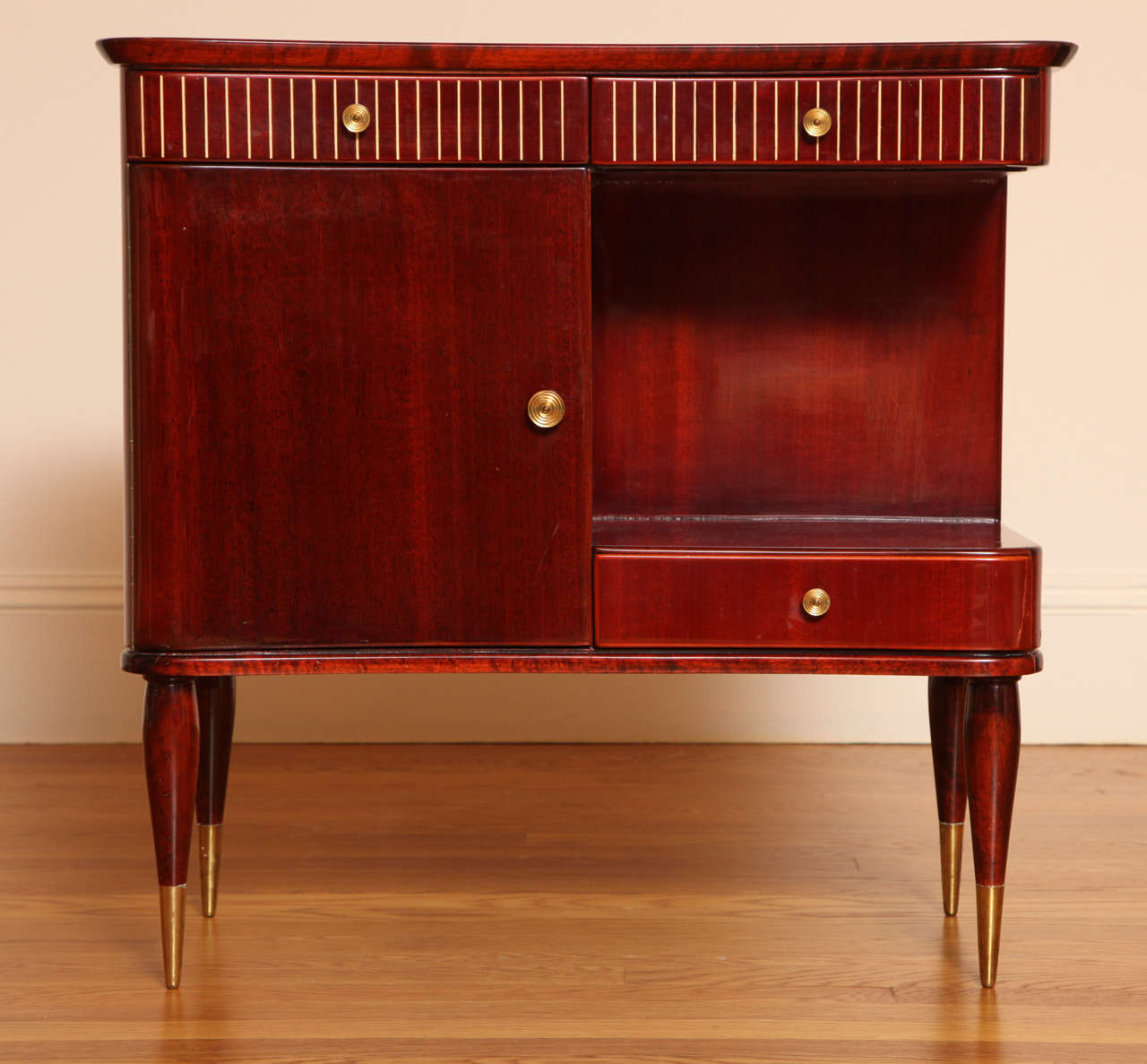 Each with elegantly incurved front fitted with two short inlaid frieze drawers, over a hinged cabinet door; raised on tapering legs terminating in brass sabots.