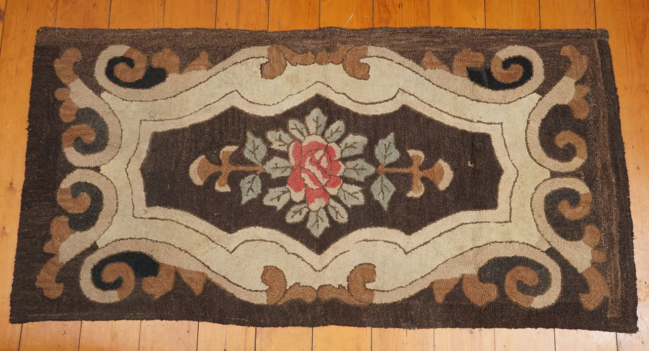Rectangular American wool hooked rug with floral decoration in the center. Hand stitched burlap backing, late 19th century. Some wear but in overall good condition.