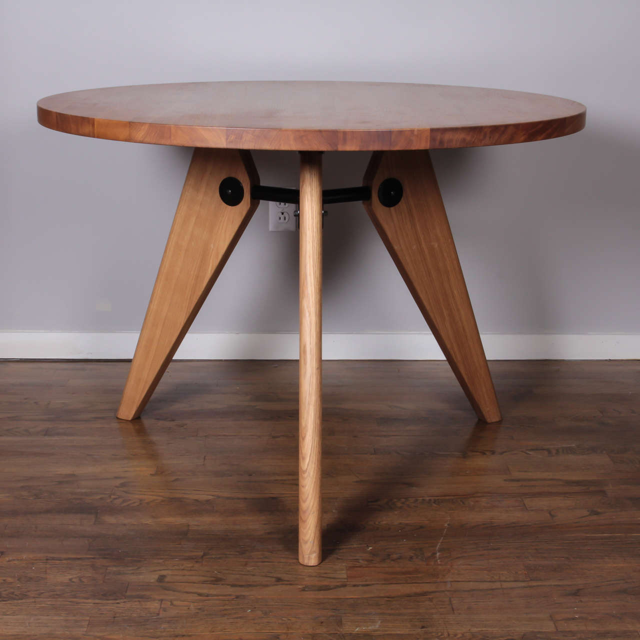 Table de salle à manger Guéridon de Jean Prouvé produite par Vitra. Fabriqué à partir de pièces individuelles de bois massif avec une finition en placage:: il donne une impression à la fois de robustesse et de légèreté.