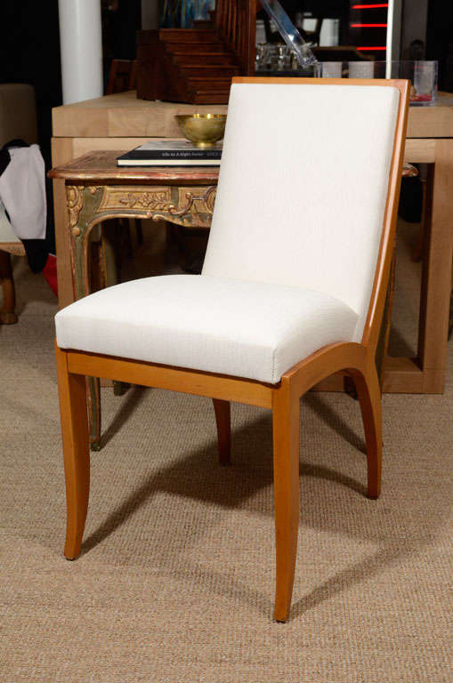 Pair of modern oak dining chairs with white linen.