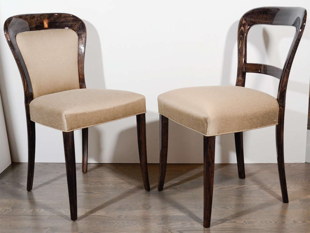 This gorgeous set of 8 modernist chairs feature a stylized arched back design.  Host and hostess chairs feature a cut-out back detail.  They are ebonized walnut and newly upholstered in bronzed metallic sharkskin fabric.