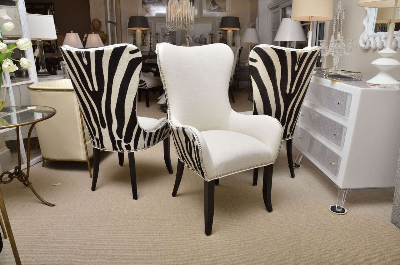 Set of 8 zebra stenciled cowhide dining chairs. The group consists of 2 arm chairs and 6 side chairs. Additional chairs can be ordered and any amount can be purchased. The arm chairs are $2250 each and the side chairs are $1950 each