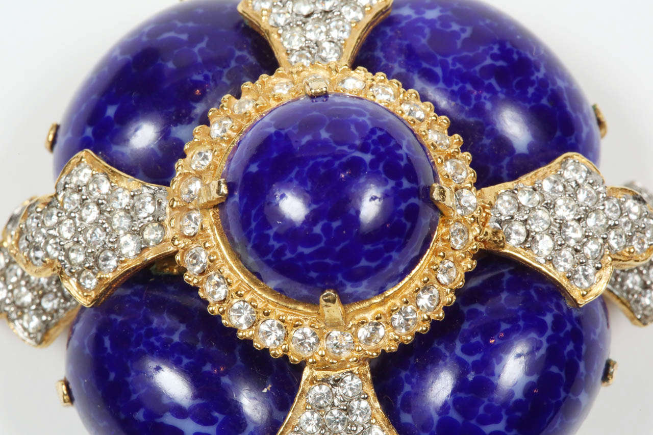 A striking pin by K.J.L. with a tier of four oval glass lapis cabochons bordered with rhinestones and topped with a rhinestone framed round glass lapis cabochon. Stamped on the back with the K.J.L. mark.